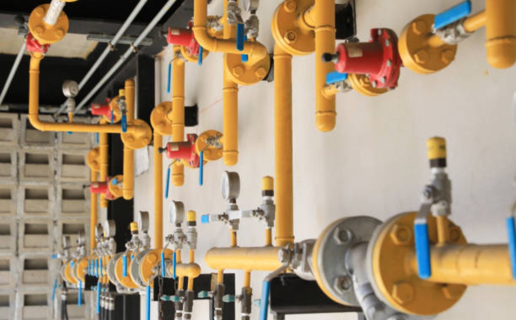 Professional Gas Installation Services with Secure Pipeline System Gas Installation Services setup featuring yellow gas pipelines with valves and pressure regulators mounted along an indoor wall.