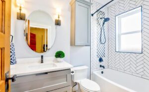 Modern bathroom with sleek vanity, round mirror, and tiled shower showcasing expert Custom Bathroom Plumbing design and fixtures.