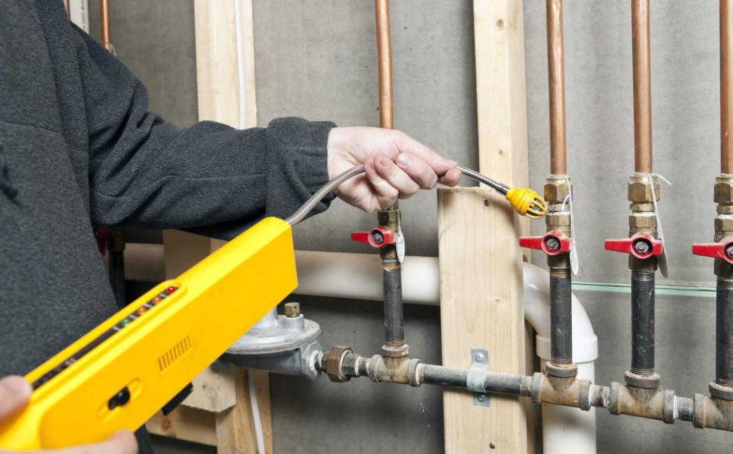 Specialist using specialized equipment to perform leak detection services on indoor plumbing pipes and valves.