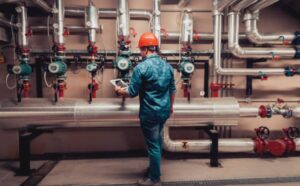 Professional plumber repairing an industrial water pipe system